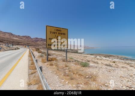 Straße Nr. 90 in der Nähe des Toten Meeres, Israel. Ein Blick auf das Tote Meer, und ein gelbes Zeichen, das in Hebräisch, Arabisch und Englisch liest, "Haben Sie einen Checkpoint vor Stockfoto