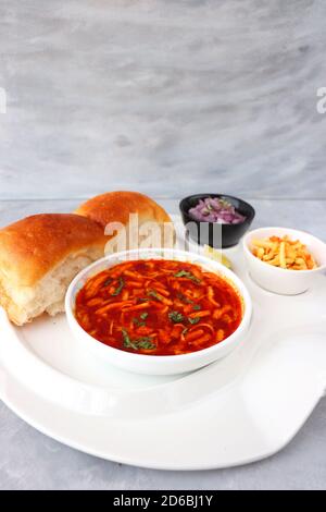 Spicy Misal Pav oder Sal Pav ist ein traditioneller Snack oder Chaat-Essen aus Maharashtra, Indien. Serviert mit gehackten Zwiebeln, Zitronenkeilchen und farsan. Stockfoto