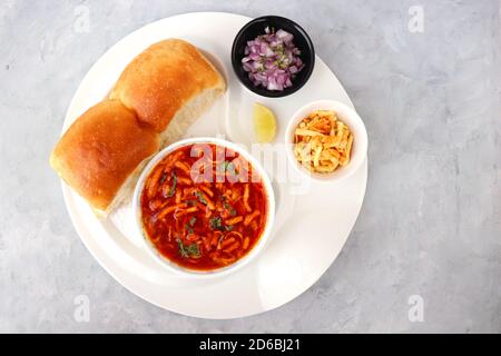 Spicy Misal Pav oder Sal Pav ist ein traditioneller Snack oder Chaat-Essen aus Maharashtra, Indien. Serviert mit gehackten Zwiebeln, Zitronenkeilchen und farsan. Stockfoto