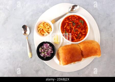 Spicy Misal Pav oder Sal Pav ist ein traditioneller Snack oder Chaat-Essen aus Maharashtra, Indien. Serviert mit gehackten Zwiebeln, Zitronenkeilchen und farsan. Stockfoto