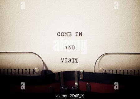 Kommen Sie herein und besuchen Sie die mit einer Schreibmaschine geschriebene Phrase. Stockfoto