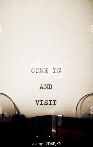 Kommen Sie herein und besuchen Sie die mit einer Schreibmaschine geschriebene Phrase. Stockfoto