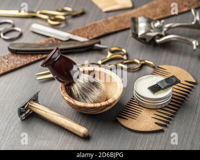 Klassische Grooming- und Frisierwerkzeuge auf Holzhintergrund. Draufsicht auf Barbershop-Instrumente, die auf dunklem Holztisch liegen. Stockfoto