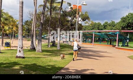 Townsville, Queensland, Australien - Juni 2020: Frau, die ihren Hund entlang der Promenade am Strand läuft Stockfoto