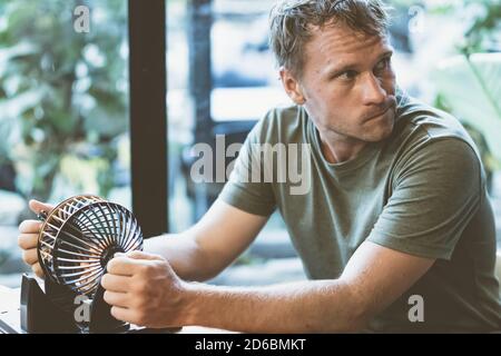 Junger Mann halten Lotto-Kugel spins kleine Bälle, Tisch loto Spiel als Symbol für zukünftige Problem Leben Krise Wahl. Blick Seite weg Fenster Gesicht erfunden Stockfoto