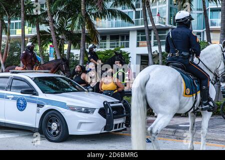 Miami, Usa. Oktober 2020. Anti-Trump-Aktivisten werden von der Polizei bei einem Protest auf der Straße vom Rathaus des Präsidenten in Miami festgenommen.Demonstranten sowohl für als auch gegen Präsident Trump versammelten sich heute Abend in der Innenstadt von Miami, wo der Präsident ein Ratstreffen mit NBC News abhielt, wo die Präsidentschaftsdebatte stattfinden sollte Bevor es storniert wurde. Der Präsident plante dieses Rathaus, um mit Rathaus Joe Bidens mit ABC-Nachrichten in Pennsylvania zu konkurrieren und ihre konkurrierenden Veranstaltungen fanden statt anstelle der abgesagten Präsidentendebatten. Kredit: SOPA Images Limited/Alamy Live Nachrichten Stockfoto