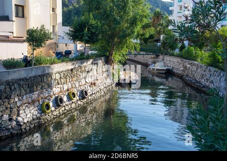 Kleiner Wasserkanal in türkischer Stadt. Stadtlandschaft mit Kanal, Booten und bunten Reflexen auf dem Wasser in der malerischen Stadt in der Türkei. Kanal in Stockfoto