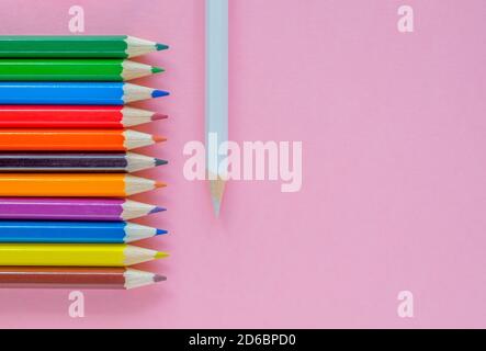 Auf einem rosa Hintergrund sind mehrere mehrfarbige Stifte angelegt Stockfoto