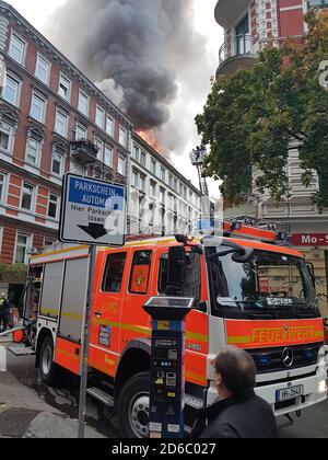 Hamburg, Deutschland. Oktober 2020. Rauch und Flammen sind bei einem Dachbrand in der Glashüttenstraße im Karolinenviertel zu sehen. Kredit: Raul Campos/dpa/Alamy Live Nachrichten Stockfoto