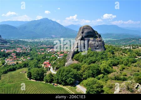 Meteora Land im Himmel: Große alte Stadt von Meteora in Griechenland. Bäume, alte Häuser, blauer Himmel und weiße Wolken. Stockfoto