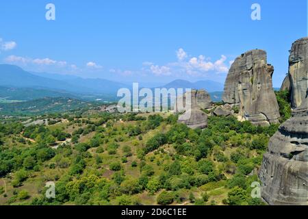 Meteora Land im Himmel: Große alte Stadt von Meteora in Griechenland. Bäume, alte Häuser, blauer Himmel und weiße Wolken. Stockfoto