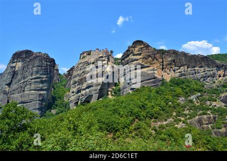 Meteora Land im Himmel: Große alte Stadt von Meteora in Griechenland. Bäume, alte Häuser, blauer Himmel und weiße Wolken. Stockfoto