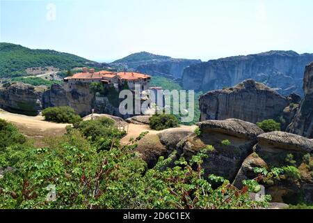 Meteora Land im Himmel: Große alte Stadt von Meteora in Griechenland. Bäume, alte Häuser, blauer Himmel und weiße Wolken. Stockfoto