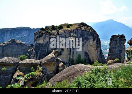 Meteora Land im Himmel: Große alte Stadt von Meteora in Griechenland. Bäume, alte Häuser, blauer Himmel und weiße Wolken. Stockfoto