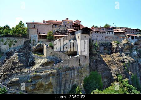 Meteora Land im Himmel: Große alte Stadt von Meteora in Griechenland. Bäume, alte Häuser, blauer Himmel und weiße Wolken. Stockfoto