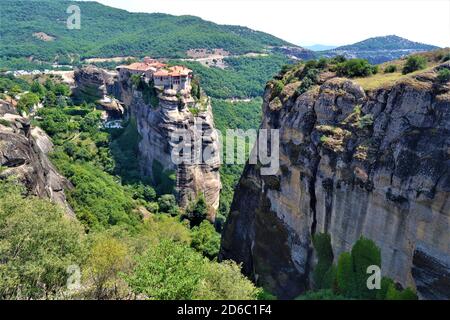 Meteora Land im Himmel: Große alte Stadt von Meteora in Griechenland. Bäume, alte Häuser, blauer Himmel und weiße Wolken. Stockfoto