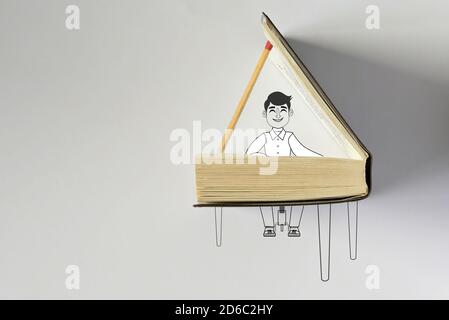 Konzept des Mannes, der Klavier auf offenem Buch spielt Stockfoto