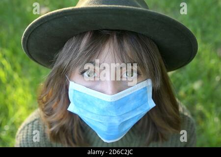 Portrait Junge Frau mit medizinischer Maske in der Natur Stockfoto