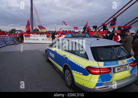 16. Oktober 2020, Hamburg: Die Teilnehmer der Demonstration stehen gegenüber einem Polizeinotfahrzeug auf der geschlossenen Autobahn 1 (A1). Am Freitagmorgen hatten rund 200 Menschen die Autobahn zwischen der Anschlussstelle Moorfleet und der Anschlussstelle Norderelbe blockiert. Nach Angaben der Polizei wollten sie die Aufmerksamkeit auf den Konflikt in Armenien lenken. Es gab Staus in und um Hamburg. Foto: Citynewtv/dpa Stockfoto