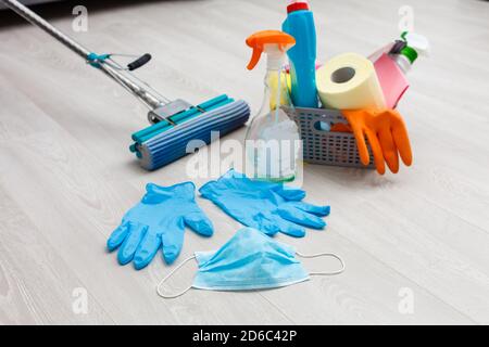 Reinigungs-, Gesundheits- und Hygienekonzept - Schutz vor Viruserkrankungen in Handschuhen mit Waschmittel und Mopp zu Hause Stockfoto