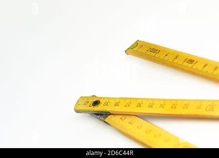 Ein gelbes, hölzernes Klapplineal isoliert auf weißem Hintergrund. Messgerät. Bau und Renovierung Stockfoto