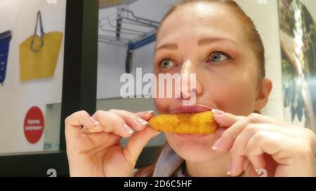 Frau essen gebratenes Huhn in Fast-Food-Restaurant Stockfoto