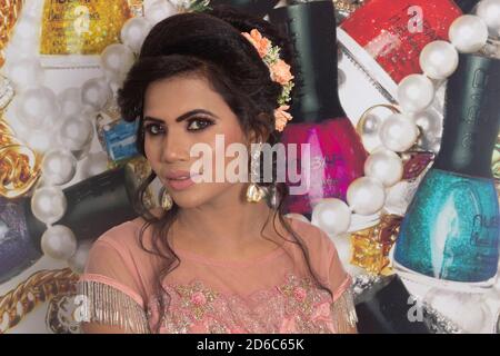 Indisches Modell in rosa Kleid und Schmuck. Seitenprofil der Fläche. Dekorativer Hintergrund. Stockfoto