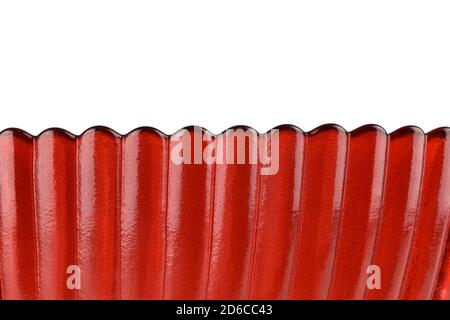 Makro-Foto von rotem Glas isoliert auf weißem Hintergrund, Nahaufnahme von schönen gewellten Rand Glas, abstrakt texturierten Kunst Hintergrund Stockfoto