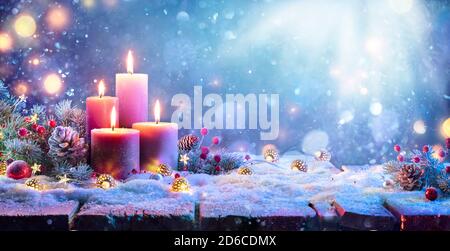 Advent - Vier Lila Kerzen Mit Weihnachtsschmuck In Glänzend Nacht Stockfoto