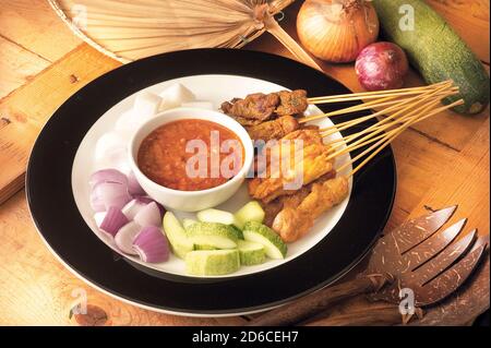 Asiatische Küche Satay serviert mit Zwiebeln, Gurken und Ketupat Stockfoto