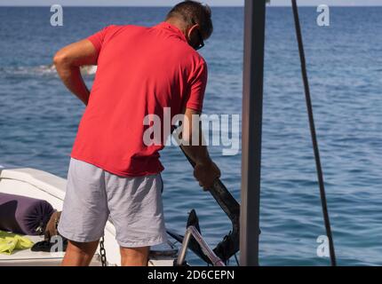 PONZA, ITALIEN - 22. Sep 2020: Segler, der den Anker eines Touristenbootes hebt Stockfoto