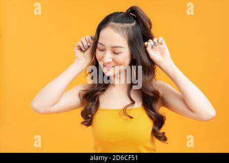 Glücklich schöne junge Frau tanzen und aufgeregt fühlen, isoliert auf Studio-Hintergrund Stockfoto