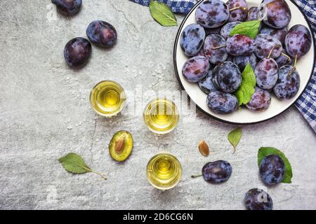 Rakija, Raki oder Rakia ist ein Balkan starke alkoholische Getränk Brandy Art auf der Grundlage fermentierter Früchte. Pflaumenrakia auf dem grauen sone Tisch, Draufsicht. Stockfoto