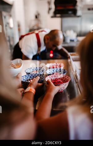 Mädchen, die nach Dessert in der Restaurantküche greifen Stockfoto