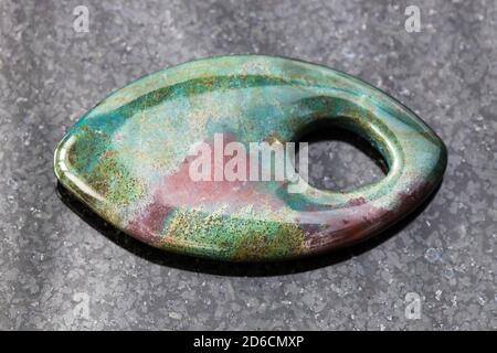 Anhänger aus Heliotrope (Bloodstone) Edelstein auf schwarzem Granit Hintergrund Stockfoto