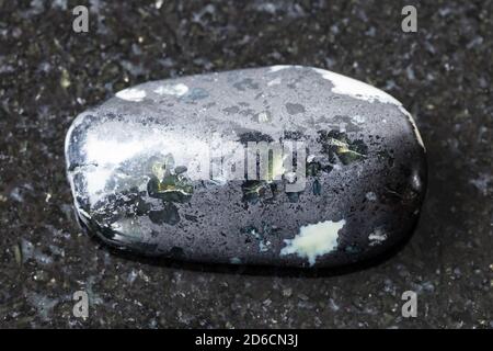 Natürliches Mineral aus geologischer Sammlung - getaumeltes Teisky Jade (Hantigyrit, chakassische Serpentin) Gestein mit Magnetit, Serpentin, Hämatit minera Stockfoto