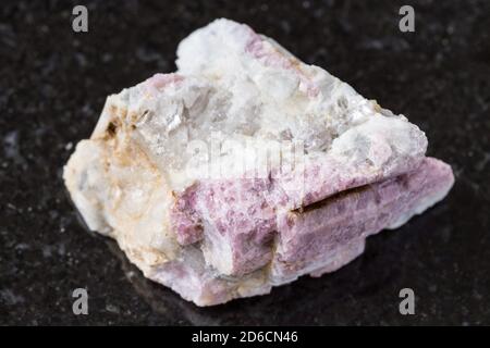 Makrofotografie der Probe des natürlichen Minerals aus der geologischen Sammlung - unpoliertes rosa Turmalin Mineral in Feldspat und Quarzgestein Von Kalba Stockfoto