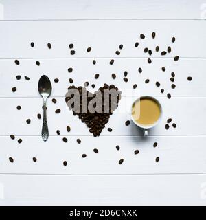 Herzform aus Kaffeebohnen mit Löffel und Tasse Kaffee, Schreibweise Ich liebe Kaffee. Stockfoto