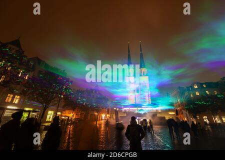 15. Oktober 2020, Sachsen-Anhalt, Halle (Saale): Passanten sehen künstlich erzeugte Auroren auf dem Hallmarkt mit Laserstrahlen und Nebel. Die Lichtinstallation 'Borealis' des Schweizer Künstlers Dan Acher ist Teil des diesjährigen Silver Salt Science and Media Festivals. Unter dem Motto "Home Earth" findet sie vom 14. Bis 18. Oktober in Halle (Saale) statt. Foto: Jan Woitas/dpa-Zentralbild/dpa Stockfoto