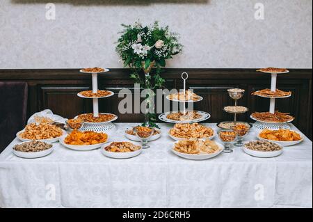 Catering-Tisch mit salzigen Snacks. Verschiedene Chips, Nüsse und Snacks. Stockfoto