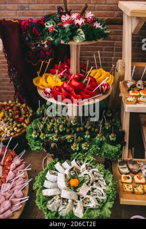 Festliche Snacks in einem Restaurant auf Holzregalen auf einem Buffettisch. Rustikaler Stil. Stockfoto