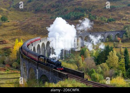 FORT WILLIAM WESTKÜSTE VON SCHOTTLAND JACOBITE DAMPFZUG DER GLENFINNAN VIADUKT MIT HERBSTFARBEN AM MORGEN UND WOLKEN VON WEISSEM RAUCH AUS DEM Stockfoto