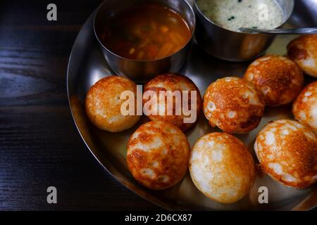 Ein Blick auf das traditionelle südindische Paddu (Reis appe) Isoliert in Platte auf Holztisch Stockfoto