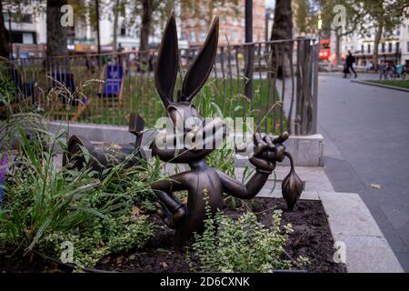 Eine Bronzestatue, die eine Szene aus einem Bugs Bunny darstellt Hanna Barbera Film mit dem Cartoon-Kaninchen essen eine Karotte In einem der Blumenbeete bildet pa Stockfoto