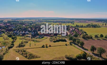 Übersicht über eine vorstädtische Industriestadt mit Feldern, Wiesen und Grünflächen in der Umgebung, Luftaufnahme Stockfoto