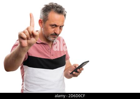 Ernst Erwachsene männliche Modell machen warten stoppen Geste mit Index Finger während SMS-Nachricht auf Smartphone mit leeren Copyspace isoliert Auf Weiß Stockfoto
