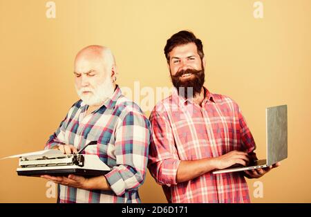 Digitale Technologien. bärtigen Männern. Vintage Schreibmaschine. Technologie Schlacht. Das moderne Leben. Vater und Sohn. Familie generation. retro Schreibmaschine laptop vs. Neue Technologie. Jugend vs Alt.business Ansatz. Stockfoto
