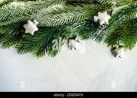 Weihnachtskarte Konzept - Rahmen mit immergrünen Ästen Mit Schnee und Kugeln Dekor auf Stein Hintergrund mit Kopie Platz Stockfoto