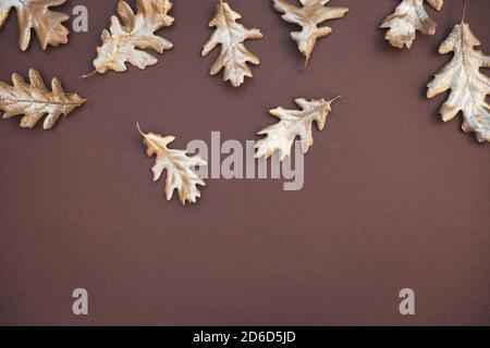 Herbstkomposition. Muster aus herbstlich goldfarbenen Blättern auf dunkelbraunem Hintergrund. Flach liegend, Draufsicht, Kopierbereich. Stockfoto