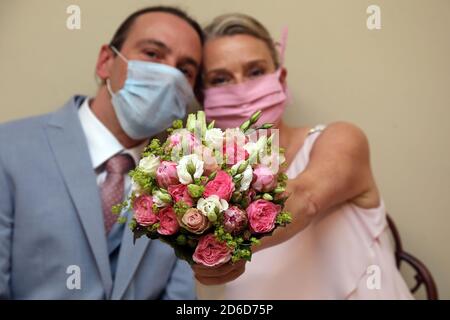 14.05.2020, Berlin, , Deutschland - Brautpaar zeigt stolz den Brautstrauß in Zeiten der Corona-Pandemie. 00S200514D354CAROEX.JPG [MODELLVERSION: Stockfoto